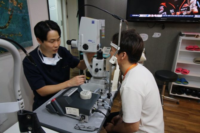 Doctor examining a patient with a lasik eye surgery test machine in Korea