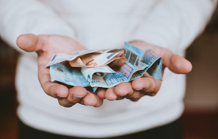 man holding foreign currency to pay for healthcare in korea