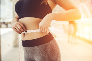 picture-of-girl-measuring-waist-size-with-measuring-tape